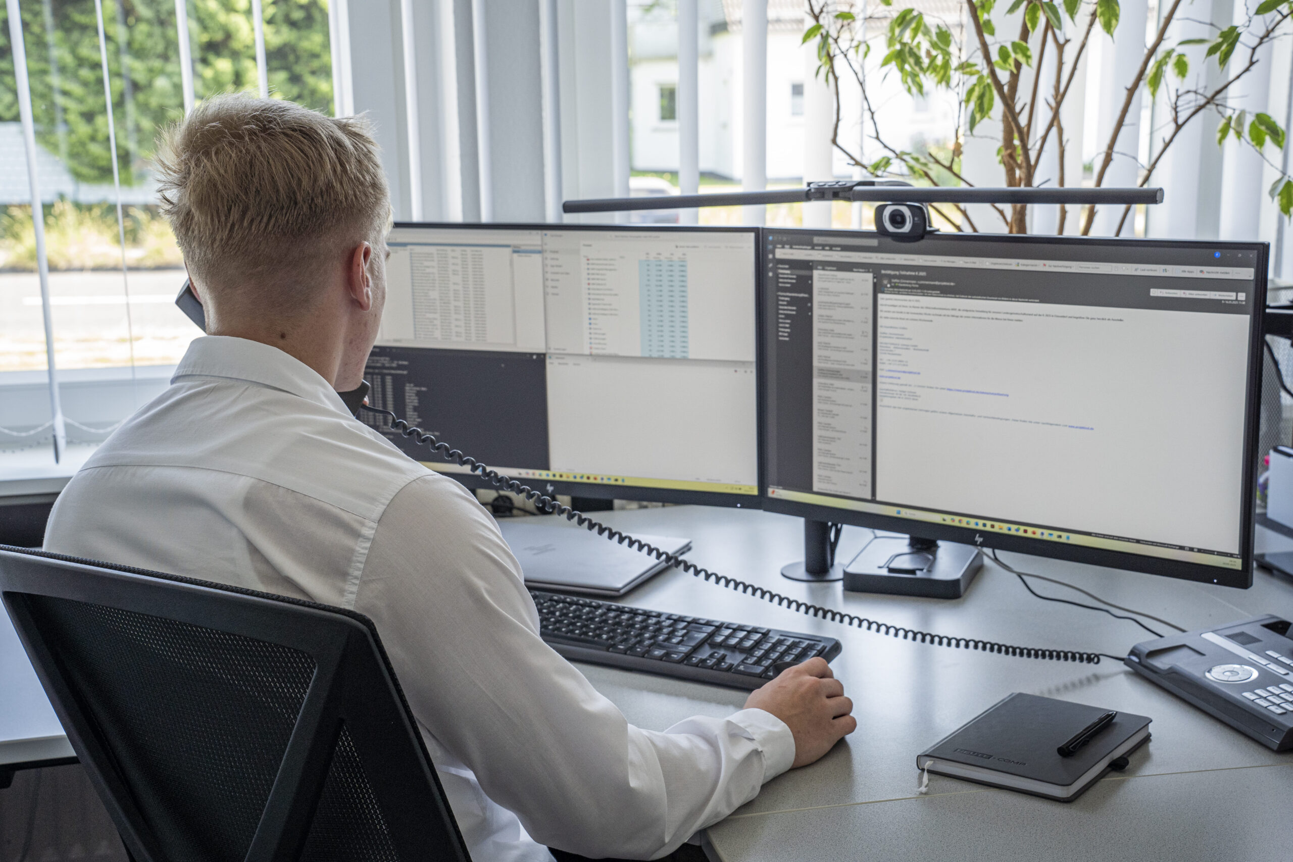 Mitarbeiter in der Verwaltung telefoniert und antwortet auf Emails