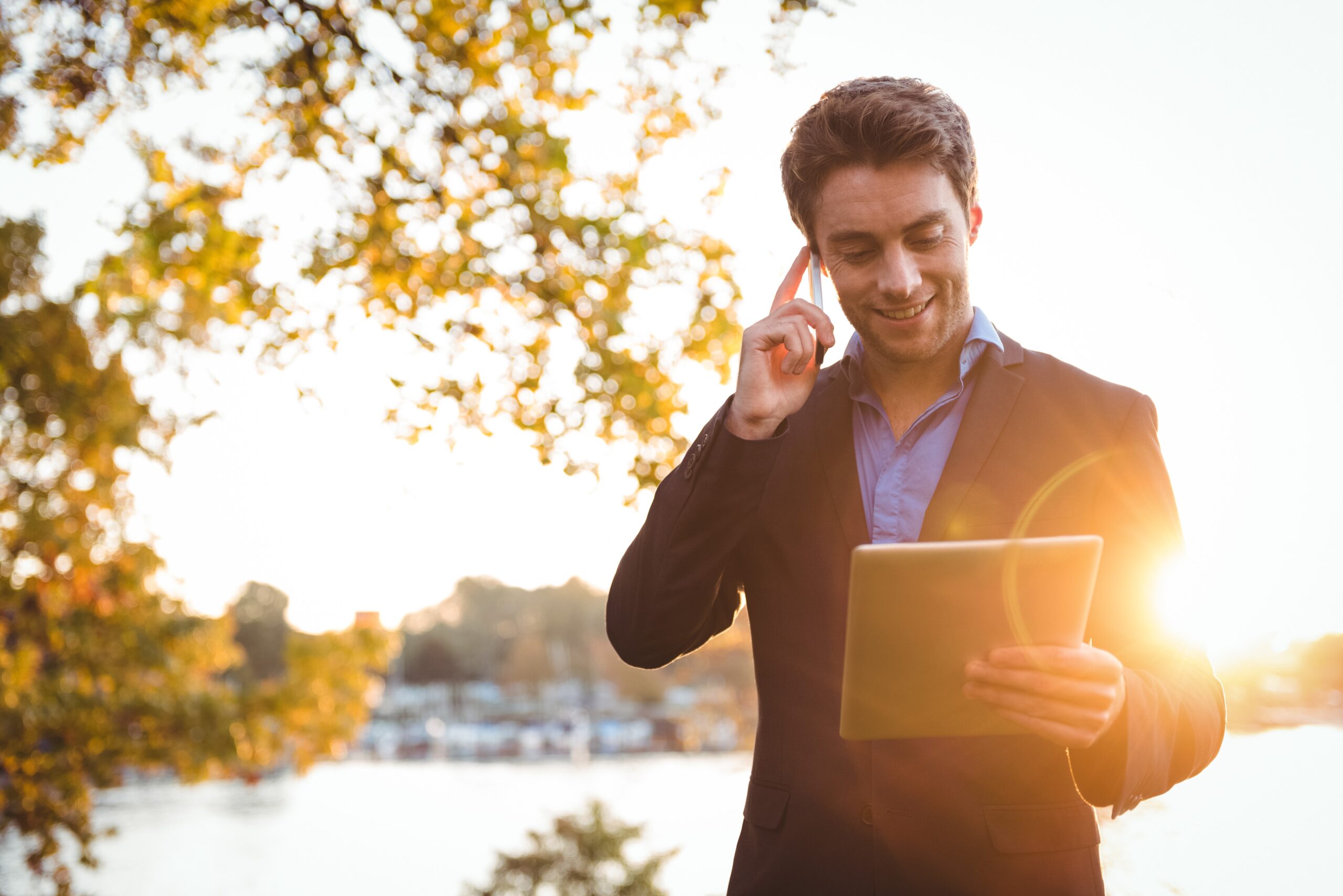 businessman talking on mobile phone while using digital tablet